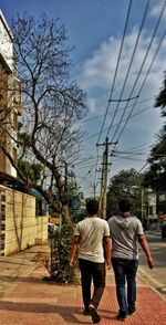 Rear view of people walking on street in city