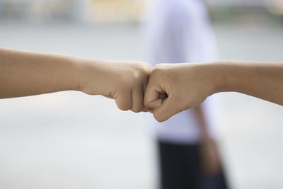 Cropped image of friends giving fist bump