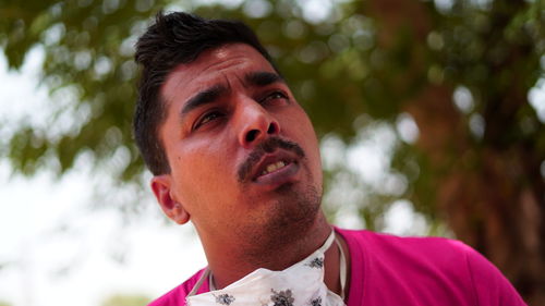 Portrait of young man looking away outdoors