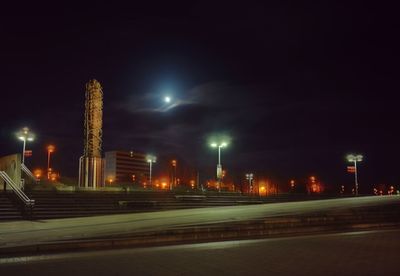 Illuminated city against sky at night