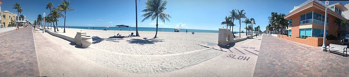 Panoramic view of people on beach against sky