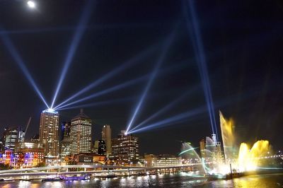 Illuminated cityscape against sky at night