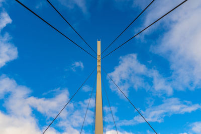 Low angle view of power lines against blue sky