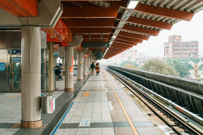 Rear view of couple walking on railroad station platform