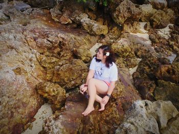 Young woman sitting on rock