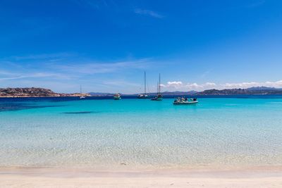 Sailboats on sea against blue sky