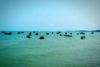 Boats in sea against clear sky