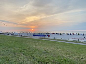 People on beach against sky during sunset
