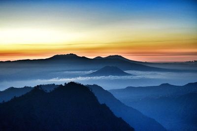 Scenic view of silhouette mountains against sky at sunset