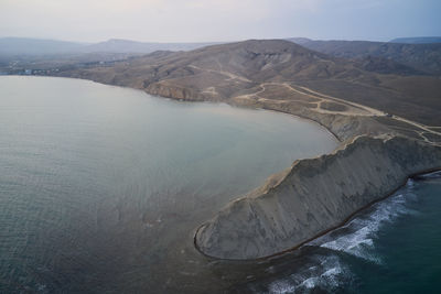 High angle view of sea and mountains against sky