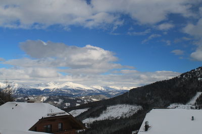 Scenic view of houses against cloudy sky