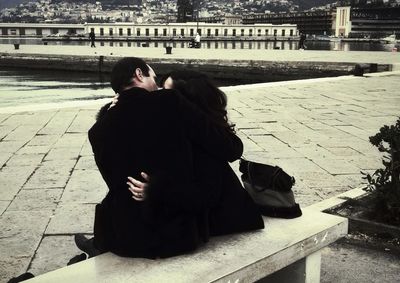 Rear view of couple sitting on shore