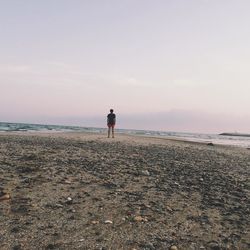 Rear view of two people walking on beach