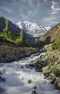 Scenic view of river amidst mountains against sky