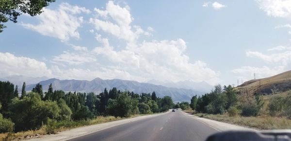 Road amidst trees against sky