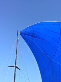 Low angle view of sailboat against clear blue sky