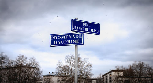 Low angle view of road sign against sky