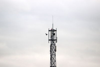 Low angle view of communications tower against sky