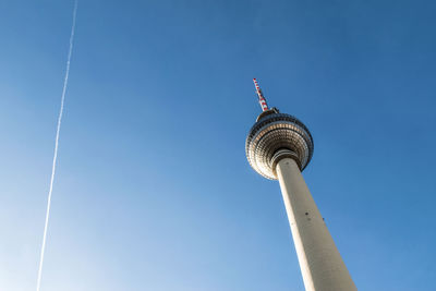 Low angle view of communications tower against blue sky