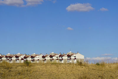 Houses on field against sky