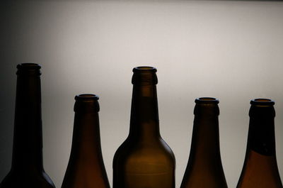 Close-up of beer bottles against wall