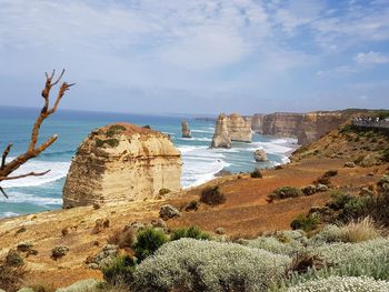 Rock formations by sea against sky