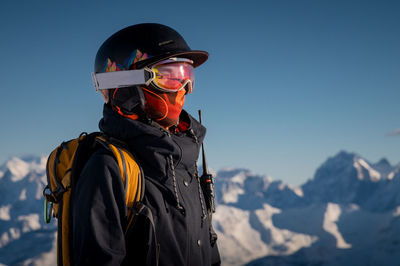 Profile of a female skier in ski goggles in the mountains. a woman in a sports ski jacket and