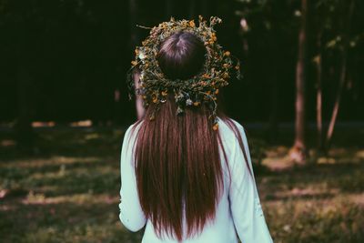 Rear view of woman wearing wreath in forest