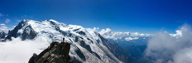 Panoramic view of snowcapped mountains against blue sky