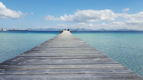 Wooden pier over sea against sky