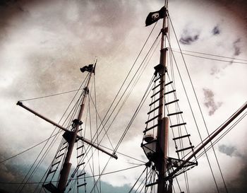 Low angle view of crane against cloudy sky