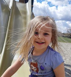 Portrait of cute smiling girl with messy hair outdoors