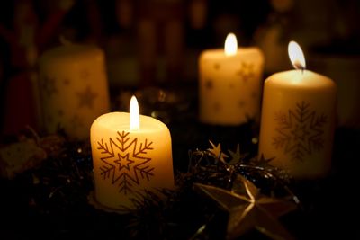 Close-up of lit candles in the dark