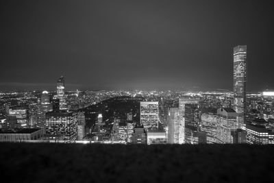 Illuminated cityscape against sky at night