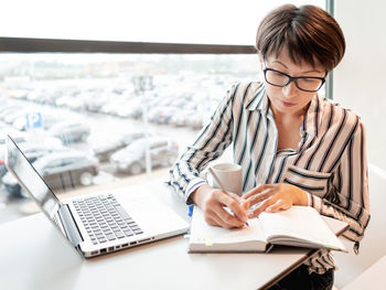 Business woman works with laptop and paper organiser in co-working center. workplace for freelancers