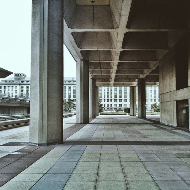 architecture, built structure, architectural column, building exterior, the way forward, column, diminishing perspective, city, indoors, corridor, building, colonnade, sunlight, empty, transportation, day, incidental people, pillar, long, vanishing point