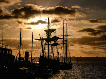 Sailboats sailing in sea against sky during sunset