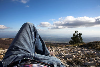 Low section of man relaxing against landscape