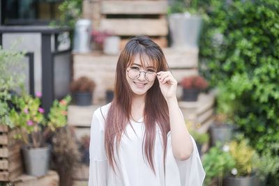 Smiling young woman against blurred plants