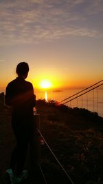 Silhouette of woman looking at sunset