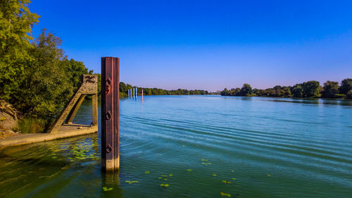 Scenic view of lake against clear blue sky