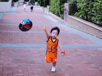 Boy with arms raised in background