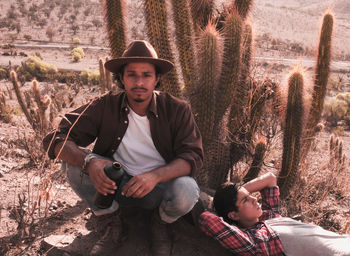 Portrait of friends sitting on land