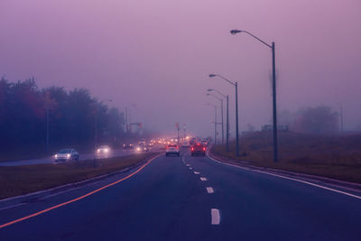 Traffic on highway in fog mist. cars on freeway road at evening in american city country. 