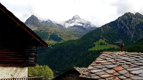 Scenic view of house and mountains against sky