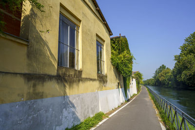 Canal amidst buildings against clear sky