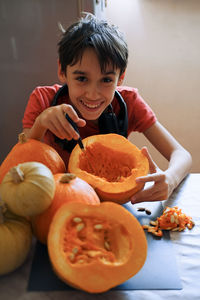 Portrait of boy with pumpkins at home