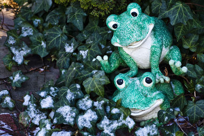 Frog sculptures amidst plants