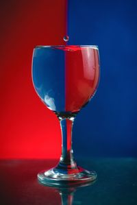 Close-up of wineglass against blue background