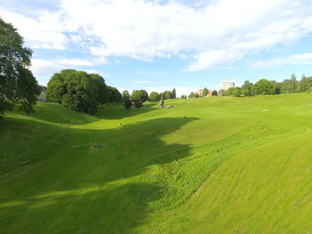 Scenic view of grassy field against cloudy sky
